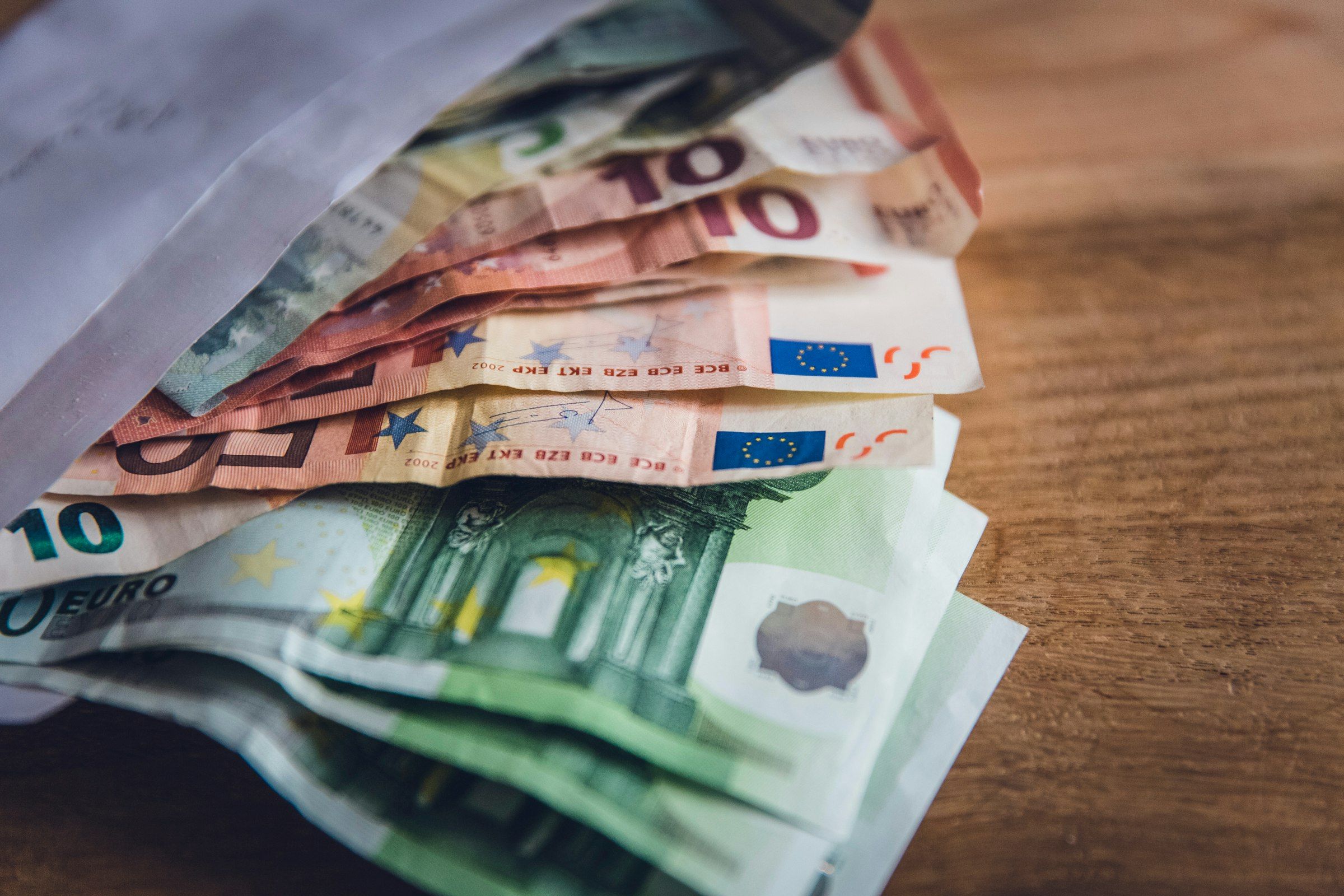 Ahşap bir yüzeye yayılmış euro banknotlar