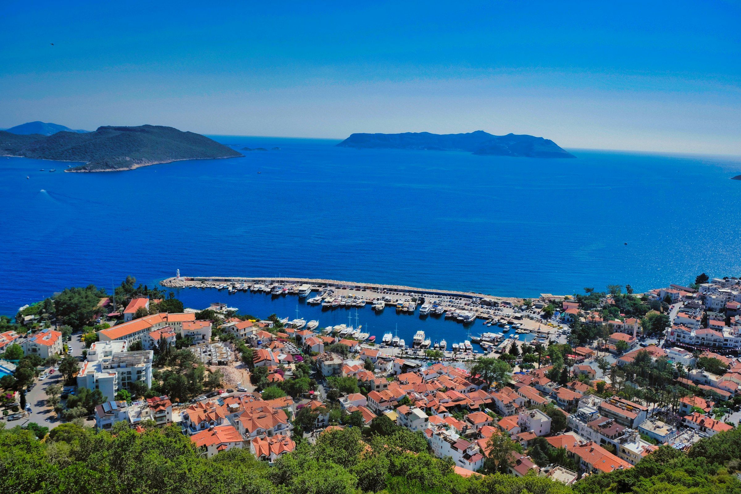 A hillside harbour town with islands across the water