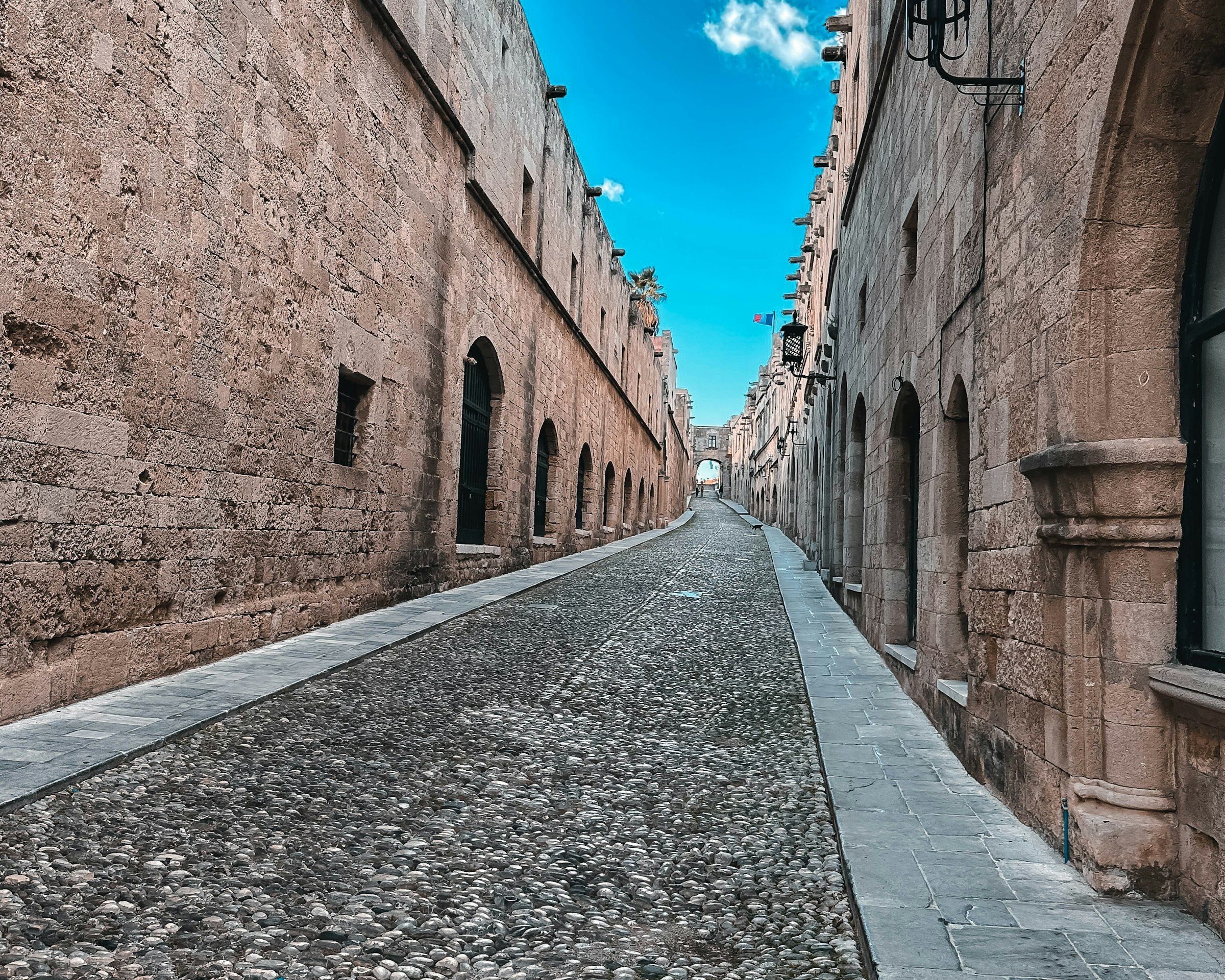 A cobblestone street lined with stone buildings in Rhodes Old Town